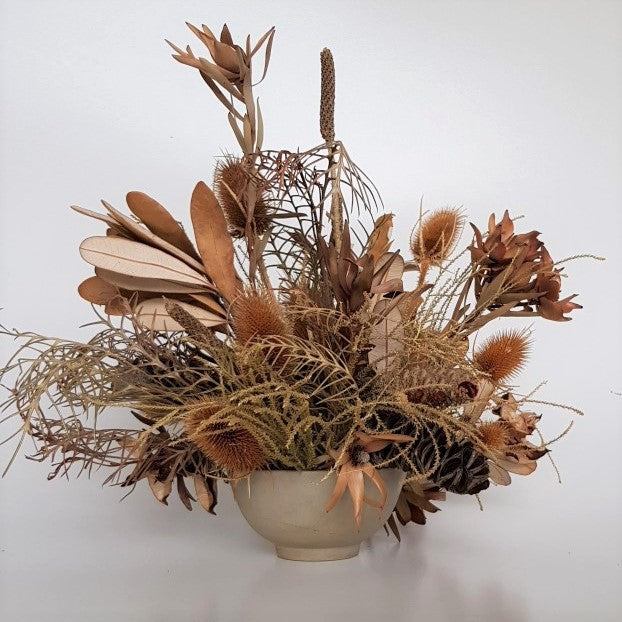 Dried ceramic bowl arrangement with banksia, teasels, grevillea, and leucadendron